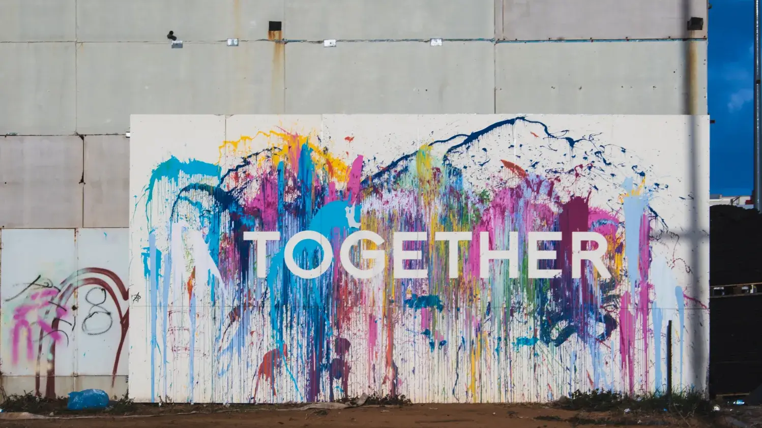 Photo d'une murale composée d'éclaboussures de couleurs vives et le mot "Together"